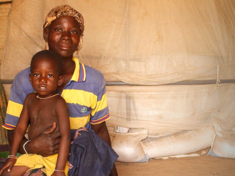 A mother holding her child in a tent