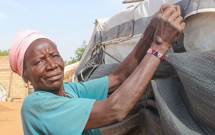 Woman tying up tarpaulins in Burkina Faso