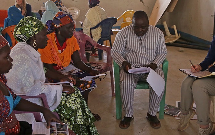 ShelterBox team member and translator speaking to three women in Minawao camp
