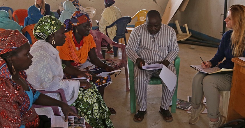 ShelterBox team member and translator speaking to three women in Minawao camp