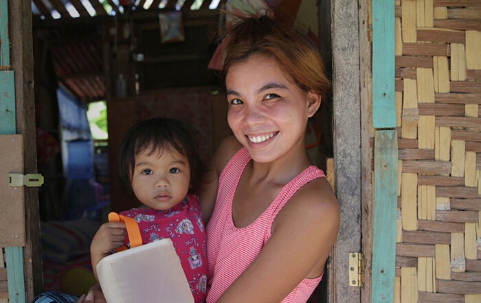 Woman holding child and a solar light