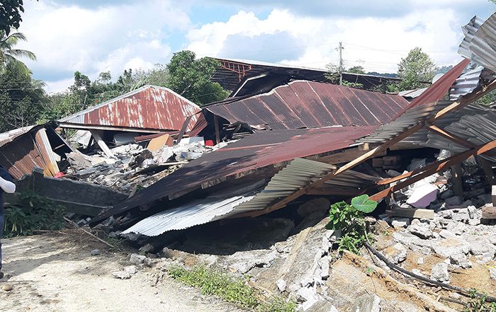 Man walking next to buildings destroyed by an earthquake in the Philippines