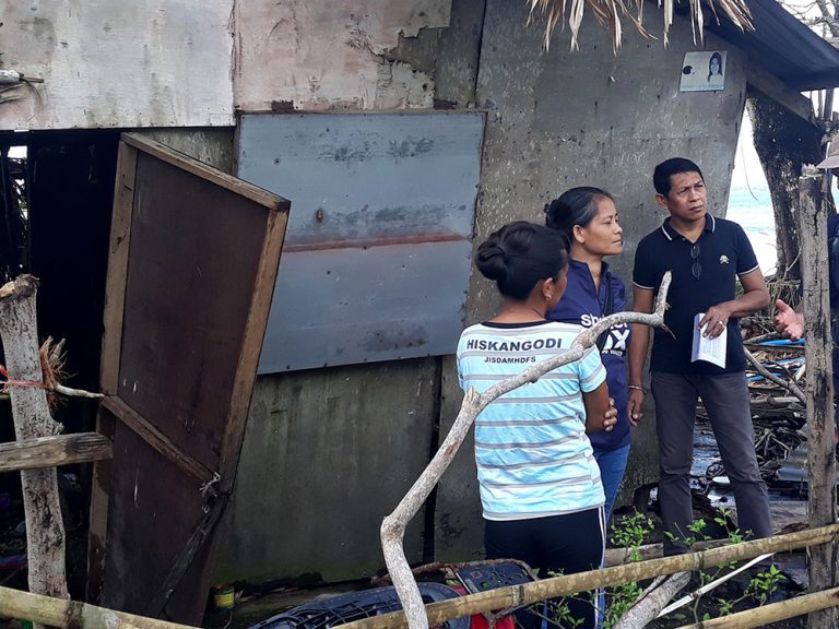 People next to damaged building in the Philippines